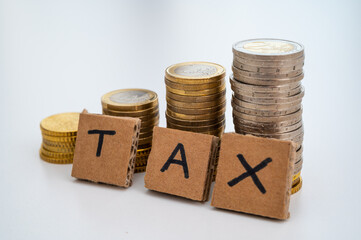 Stacks of coins, and next to them cardboard squares that form the word 