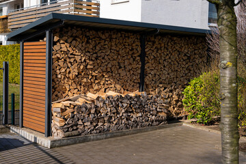 Shed in the yard with stacked firewood for the fireplace.