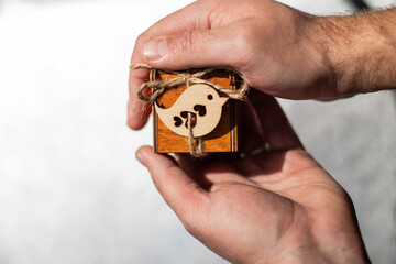 Fototapeta premium small wooden box in men's hands, offer of hands and hearts, a gift for a birthday