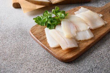 Fototapeta Delicacy fish smoked halibut served with parsley for eating on wooden cutting board. Close up. Rich of healthy omega 3 unsaturated fats. obraz