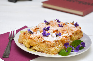 still life with cake decorated with violet flowers