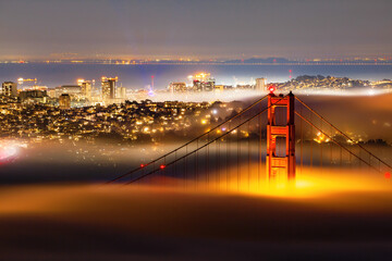 Incredible fog over Golden Gate Bridge at night in San Francisco, California, USA