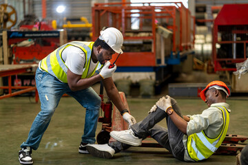 African American factory worker having accident while working in manufacturing site while his colleague is asking for first aid emergency team using walkie talkie radio for safety workplace concept - obrazy, fototapety, plakaty