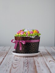 Homemade Easter cake, anointed with cream and roses and decorated with a bow of pink ribbon. The...
