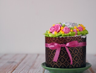 Homemade Easter cake, anointed with cream and roses and decorated with a bow of pink ribbon. The confectionery treat