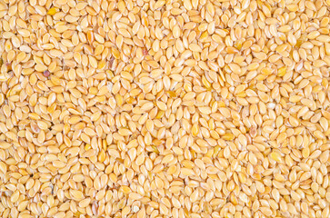 Gold flax seeds texture as background.