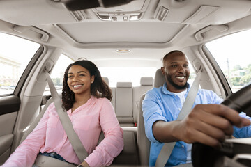 Happy black couple enjoying drive on new car