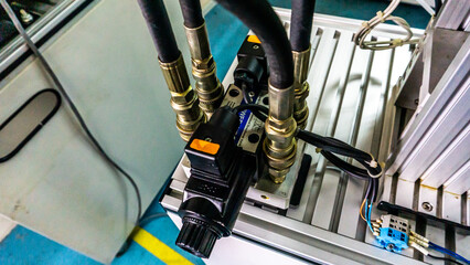 Close up view of 4/3 ways Solenoid Operated Directional Valves connected to hydraulic circuit on a industrial electrical hydraulic pressing machine. Selective focus.
