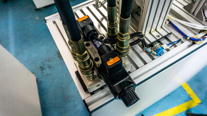 Close up view of 4/3 ways Solenoid Operated Directional Valves connected to hydraulic circuit on a industrial electrical hydraulic pressing machine. Selective focus. © Aiman Khair