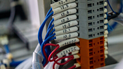 Close up view of the wiring cable connect to terminal block connector on a industrial electrical machine. Selective angle and focus. Industrial working concept.