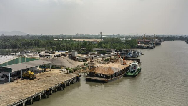 Aerial time lapse view of an excavator working on a carrier boat at Tapi river in Surat Thani, Thailand
