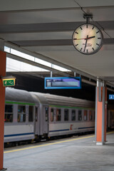 the train is standing on the train station platform, on the clock the time of departure