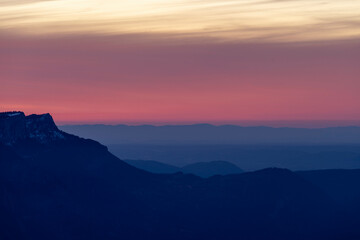 Mountains blue silhouettes during sunset and red clouds