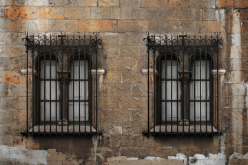 Fototapeta na wymiar Old vintage windows with bars. Brown brick wall