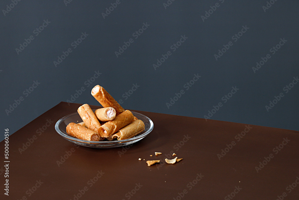 Poster Studio shot of a plate with cream wafers on a table