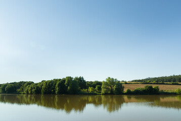 Fototapeta na wymiar Natural fishing pond in summer, rural Czech Republic