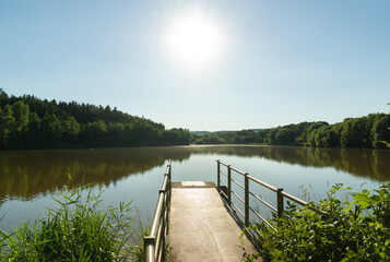 Fototapeta na wymiar Large pond with jetty in summer, rural Czech Republic