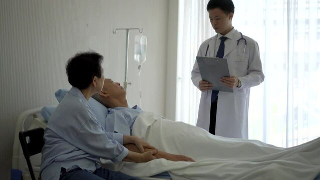 Asian doctor man taking care and check on medical round with senior patient