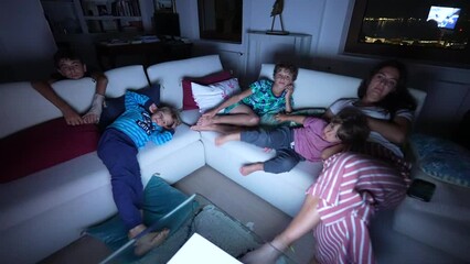 Kids sitting at couch at night watching movie