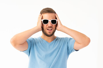 Young man on white background making a frightened expression