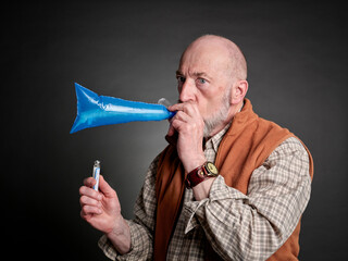 Head and shoulders portrait of a senior man performing breath test to diagnose SIBO (small intestinal bacterial overgrowth)