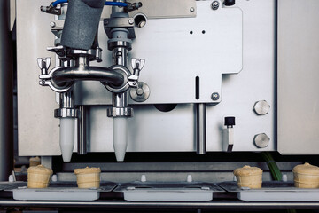 Manufacturin for automatic production of ice cream cones. Conveyor belt in waffle cups, creme brulee. Sweets modern factory. Food dairy industry, automated technology equipment and engineering concept