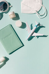 Summer vacation travel concept composition with airplane, face mask, cosmetics and passport on the...