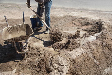 Worker prepare concrete with shovel at construction site.