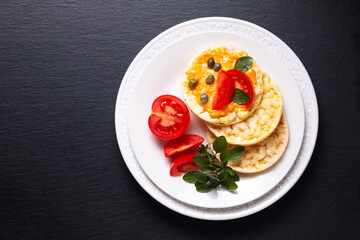 Food concept Organic Corn Crackers in white plate on black slate stone plate with copy space