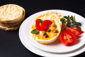 Food concept Organic Corn Crackers in white plate on black slate stone plate with copy space