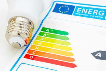 LIGHTBULB AND SCALE OF THE EUROPEAN UNION ENERGY EFFICIENCY CERTIFICATION. SUSTAINABLE AND EFFICIENT HOME CONCEPT.
