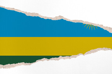 Ripped paper background in colors of national flag. Rwanda