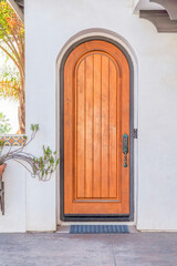 Fototapeta na wymiar Arched wooden door against the white wall at San Clemente, California