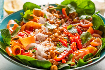 Vegan bowl with white bean, fresh spinach, carrot, red pepper, shallot, coriander and tomatoes.