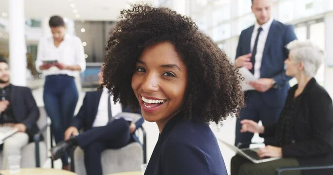 Its great to be part of such a remarkable team. 4k video footage of a young businesswoman smiling in an office with her colleagues in the background.