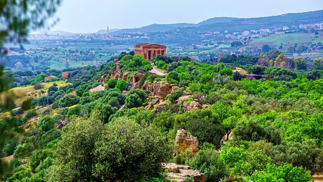 Aerial view of historic Valle Dei Templi between green plants and trees in mountaintop in Sicily - time lapse