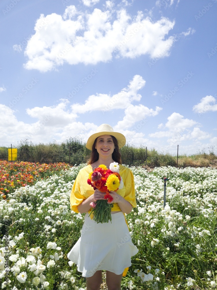 Wall mural happy woman in a field of flowers on a bright day