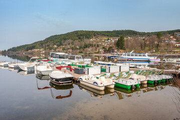 Fototapeta na wymiar Pontons avec bateaux, barques et pédalos pour visite touristique et loisir au lac de Gérardmer dans les Vosges.