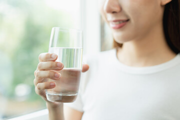 Clean freshwater concept. Woman drink mineral water in the morning for good health.