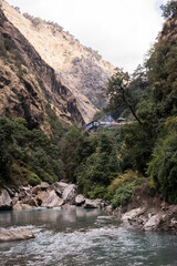 Photographie d'une maison au dessus d'une rivière dans des gorges au Népal