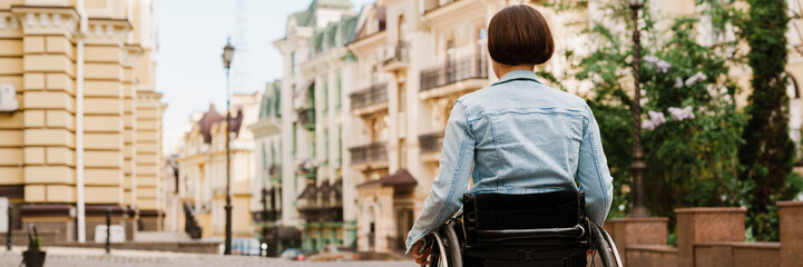 Brunette woman sitting in wheelchair on city street