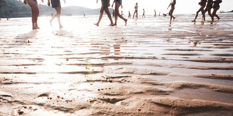 Fototapeta na wymiar people walking on the beach at sunset