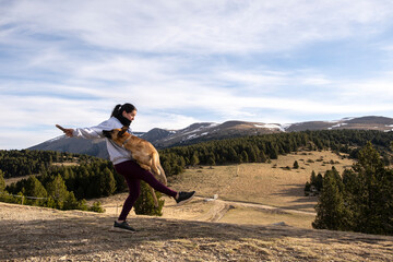 Chica con su perro en la montaña