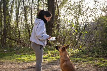 Mujer adiestrando a su perro en el bosque