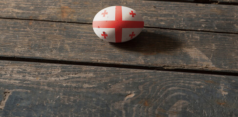 Flag of Georgia on a painted egg on a wooden board. Easter in Georgia. Painted eggs. Easter