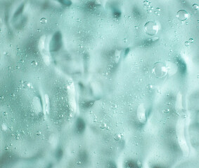 Green transparent gel texture filled with air bubbles. Development of cosmetics. Research in cosmetology.