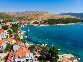 Obraz premium Croatia. Summer. Sunny day. Coast of the Adriatic Sea. Small town by the sea. Holiday season. Popular tourist spot. Drone. Aerial view