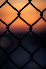 Fototapeta premium Blurry sunset behind a fence
