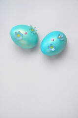 Blue Easter eggs with flowers on a gray background.