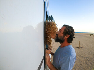 Adult man and woman kissing during summer holiday vacation. Mature man outside a camper van kiss...